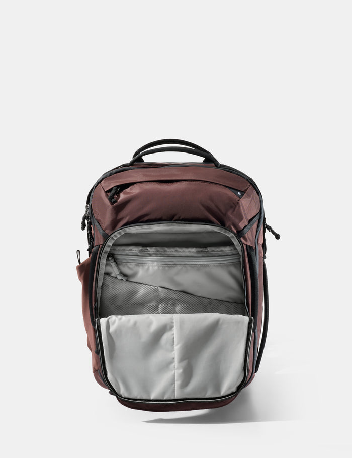 Backpack with garnet top section and gray bottom section on a white background