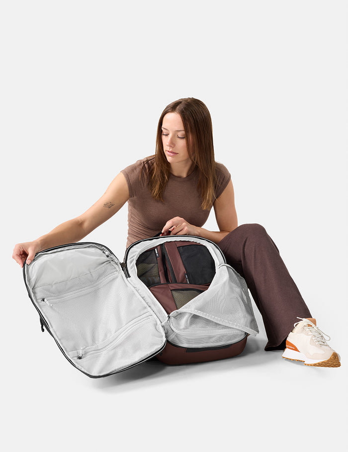 Woman unpacking a large suitcase on a white background