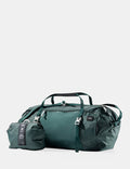 Green travel bag with smaller pouch on a light gray background