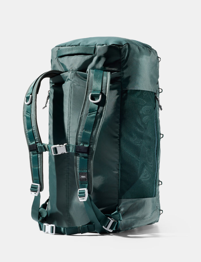 Green backpack with multiple straps on a white background