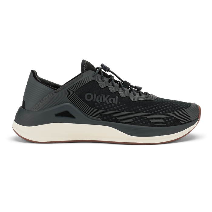 Black Olukai ʻAhi athletic shoe with cream midsole and textured upper, shown in profile view.