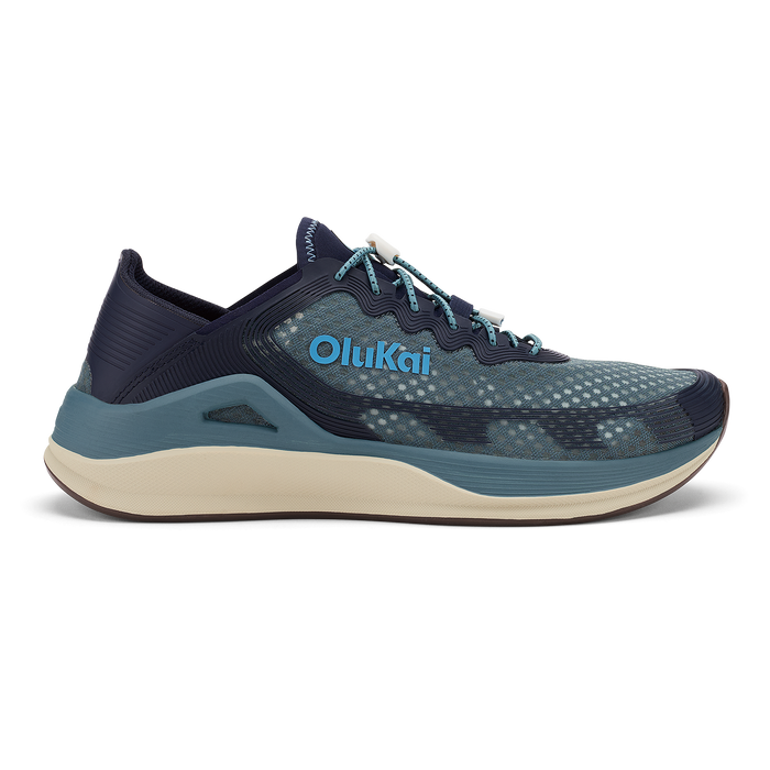 OluKai ʻAhi running shoe in storm and trench blue with cream midsole and teal accents.