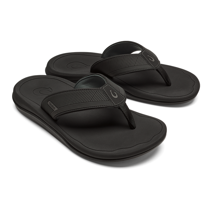 Pair of black thong sandals with textured straps and cushioned soles, shown from a three-quarter view.