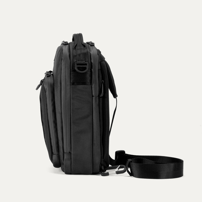 Side view of Travelpro Altitude Crossbody 6L in Black, showing D-ring and detachable strap attachment.