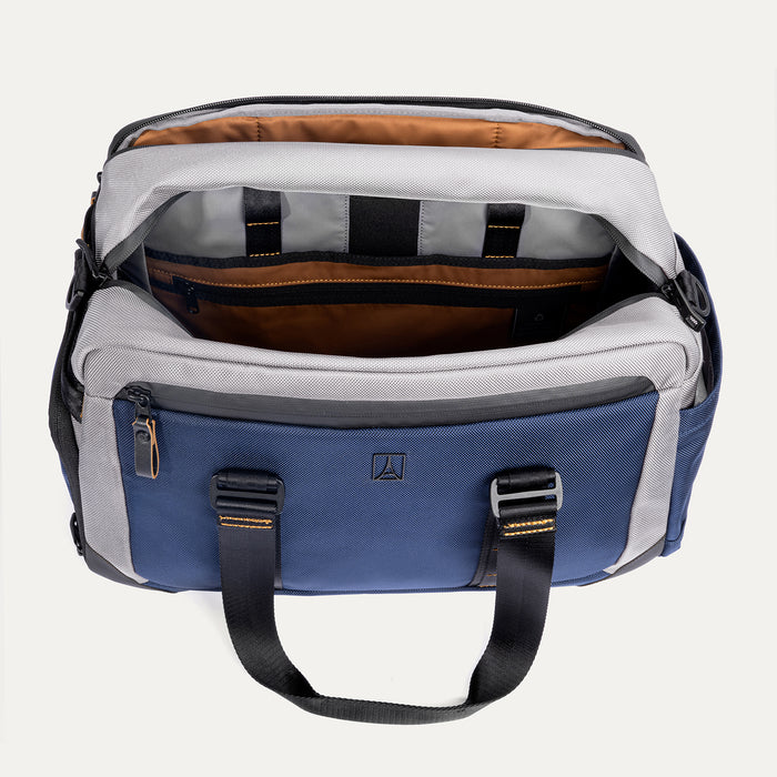 Top-down view of the Travelpro Altitude Day-to-Day Duffel in Stellar Navy/Grey, showing interior compartments with padded laptop sleeve.
