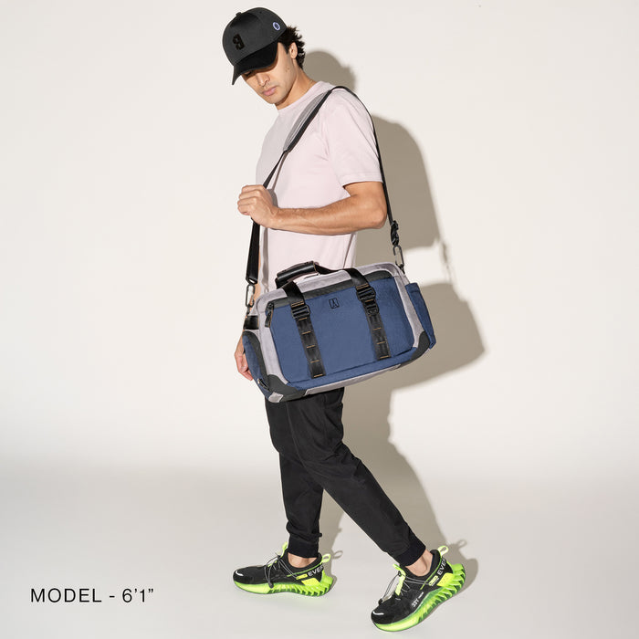 Person wearing a stellar navy duffel over the shoulder over the shoulder on a white background