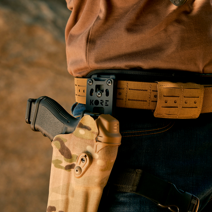 Side View of Person Wearing Kore Essentials Coyote Laser Cut Molle Battle Belt with a Kore Essentials Black Holster Mount Attached to the Battle Belt