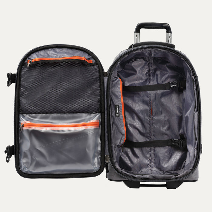 interior view of the open gray black bold by travelpro carry-on expandable rollaboard suitcase showing a spacious main compartment with two adjustable hold-down straps and a large zippered mesh lid pocket alongside a clear plastic wet pocket with orange zipper trim.