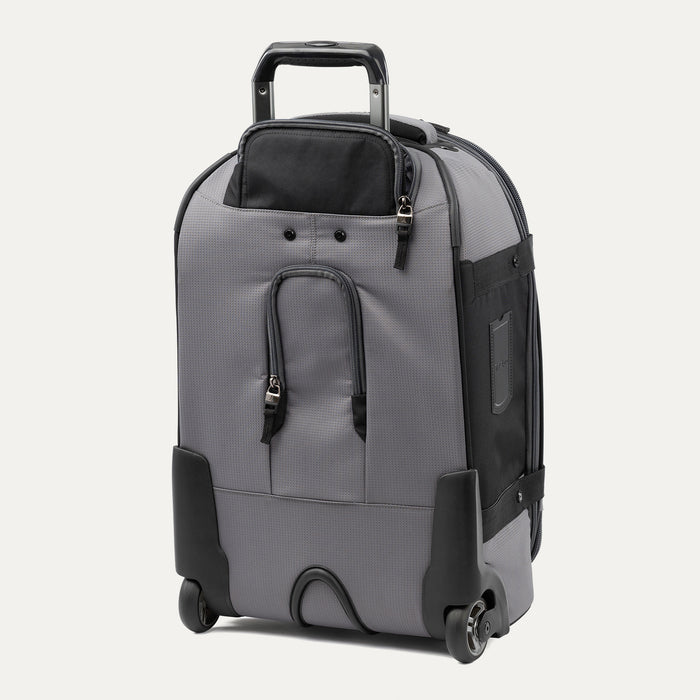 rear three-quarter view of the gray black bold by travelpro carry-on expandable rollaboard suitcase standing vertically, showing its protective skid guards, molded corner guards, reinforced wheel housings, two high-performance ball-bearing wheels, and extended telescoping handle.