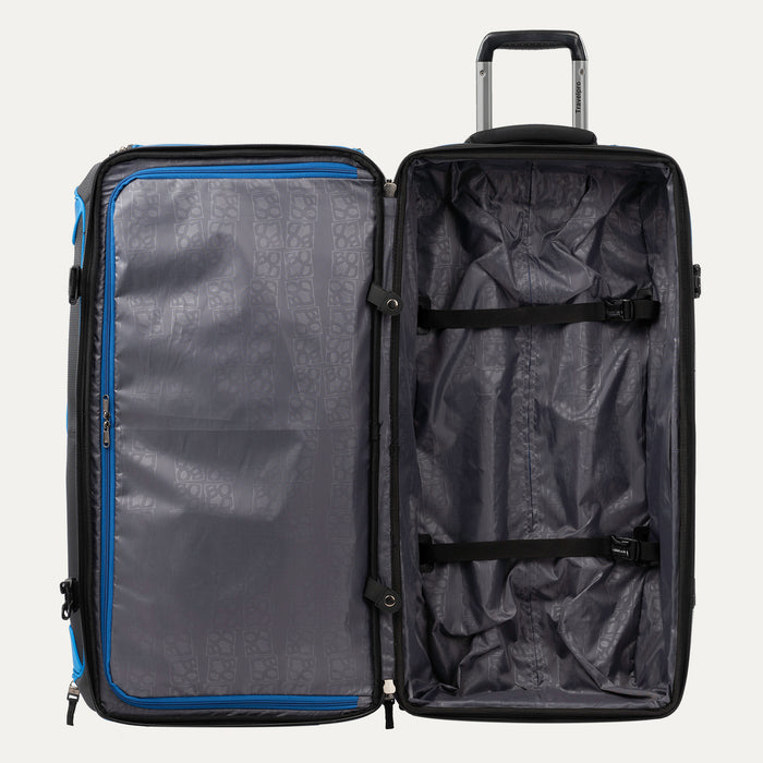interior view of the open blue black bold by travelpro large check-in drop-bottom rolling duffel bag showing the spacious main compartment with two adjustable tie-down straps and a large zippered mesh pocket on the inside lid.