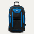 front view of the blue black bold by travelpro large check-in expandable rollaboard suitcase standing upright, showcasing its rugged black and blue polyester exterior, spacious front zippered pocket, sturdy rubberized carry handle, and extended telescoping aircraft-grade handle.