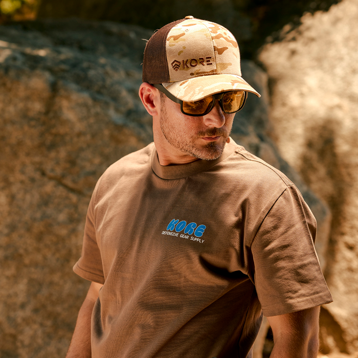 Man Wearing a Kore Essentials Hat, Shirt and a Pair of Kore Commander Sunglasses with Amber Lenses