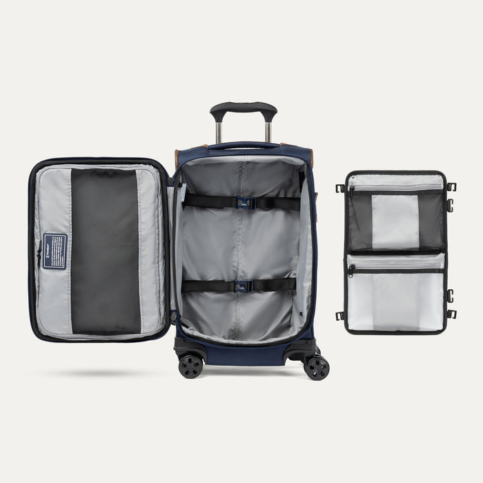 Interior view of the Crew Classic Carry-On Spinner in Patriot Blue, showing the lightweight softside design, PowerScope Lite telescoping handle, protective corner guards, and multi-directional spinner wheels against a clean off-white background.