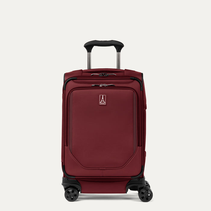 Front-three-quarters view of the Crew Classic Carry-On Spinner in Rosewood Red, showing the lightweight softside design, PowerScope Lite telescoping handle, protective corner guards, and multi-directional spinner wheels against a clean off-white background.