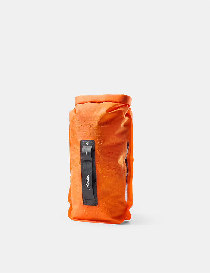 Orange dry bag with a black label on a white background