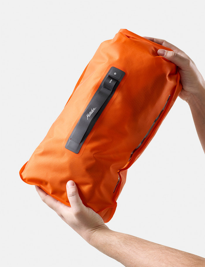 hands holding orange dry bag