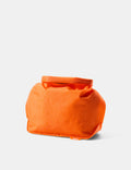 Orange toiletry bag on a light gray background