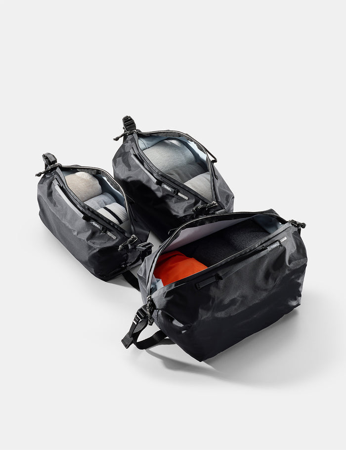 black gear cubes with open compartments on a light gray background