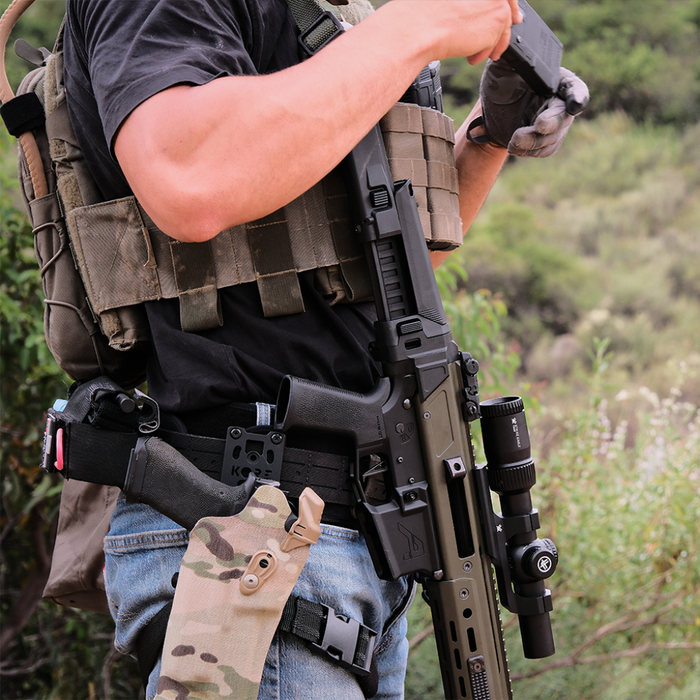 Person Wearing a Black Kore Essentials Laser Cut Molle Battle Belt with a Black Kore Holster Mount