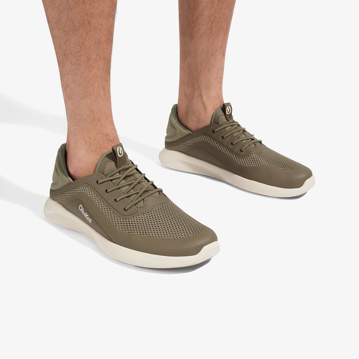 Tan and cream lace-up athletic shoes with mesh upper and white sole, shown on model's feet.
