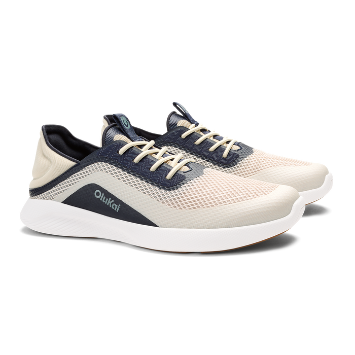 Cream and navy mesh athletic shoe with white sole and tan laces, shown from side angle.