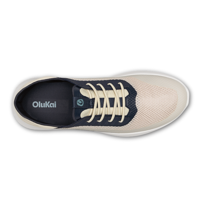 OluKai Kialoa sneaker in cream and navy with cream laces, shown from top view.