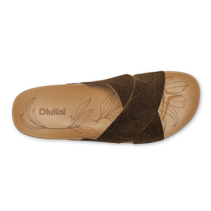 Tan sandal with dark brown textured upper strap and leaf-etched sole, viewed from above.