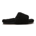 Black fuzzy slip-on slipper with cushioned sole and fluffy upper, shown in profile view.