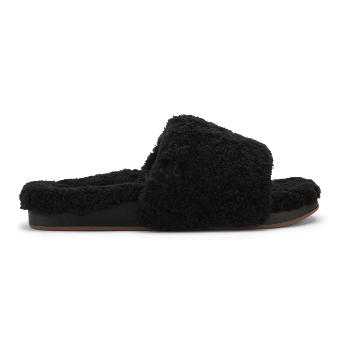 Black fuzzy slip-on slipper with cushioned sole and fluffy upper, shown in profile view.