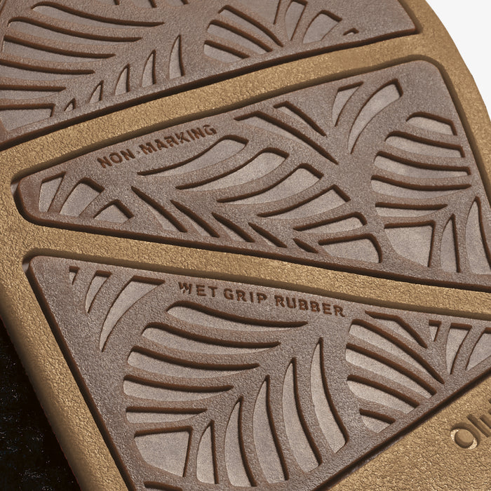 Close-up of sole showing textured tread pattern with "Non Marking" and "Wet Grip Rubber" labels on tan and brown rubber secti