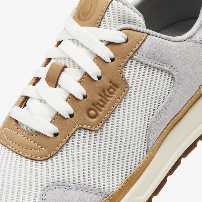 White and tan lace-up sneaker with mesh and suede paneling, white laces, and embossed branding.