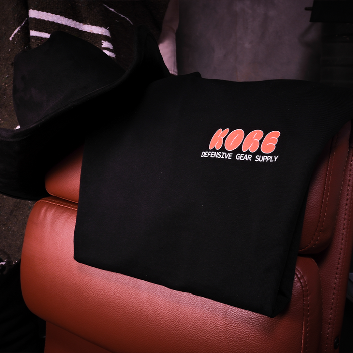 Black Kore Essentials Bubble T-Shirt Resting on a Leather Chair with a Black Cowboy Hat
