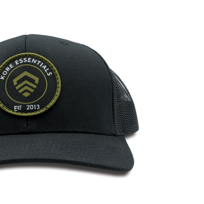 Side View of Black Kore Essentials Trucker Cap with Kore Logo Embroidered on Front