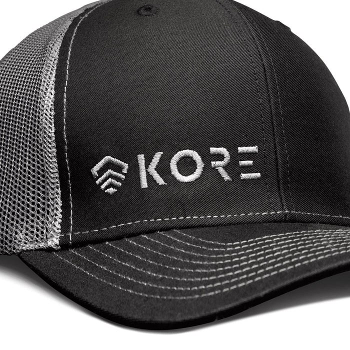 Closeup View of Black and Grey Kore Essentials Trucker Cap With White Kore Logo