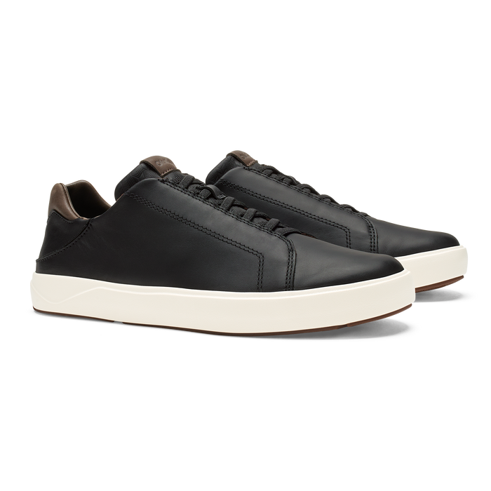 Black leather sneakers with cream rubber sole and dark brown heel collar detail, shown in side profile.