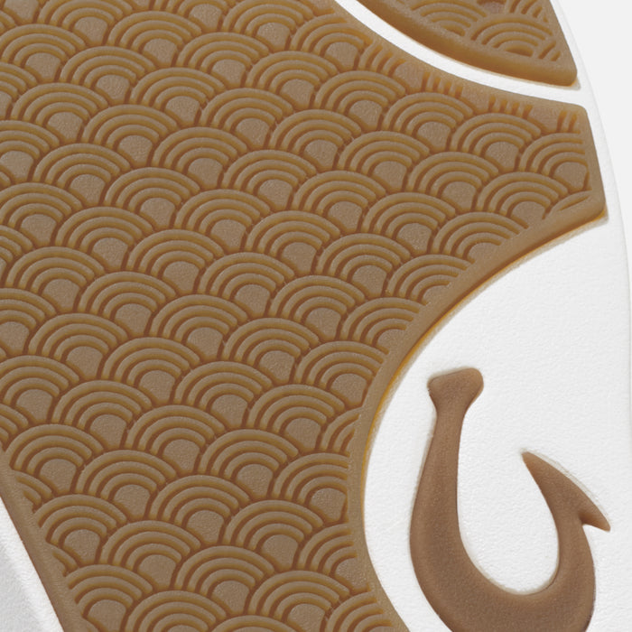 Shoe sole detail showing tan geometric wave pattern with white trim and hook accent.