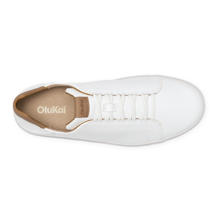 White leather sneaker with tan interior lining, white laces, and OluKai branding, shown from above.