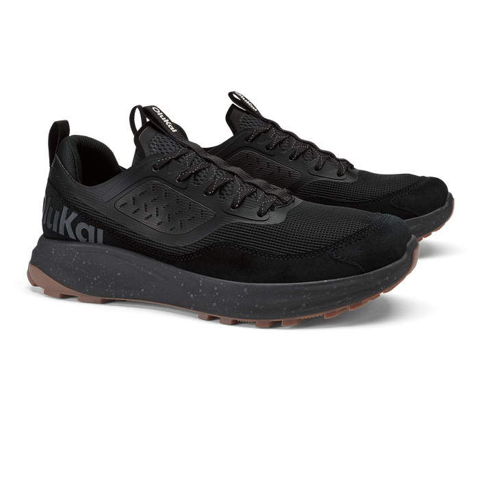 Black lace-up athletic shoe with mesh upper, cushioned midsole, and speckled sole detail.