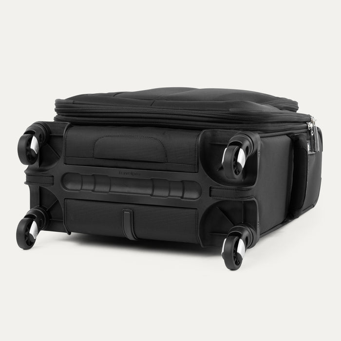bottom view of the black travelpro maxlite 5 international carry-on spinner showing four 360-degree rotating spinner wheels, protective wheel housings, and a bottom grab handle.