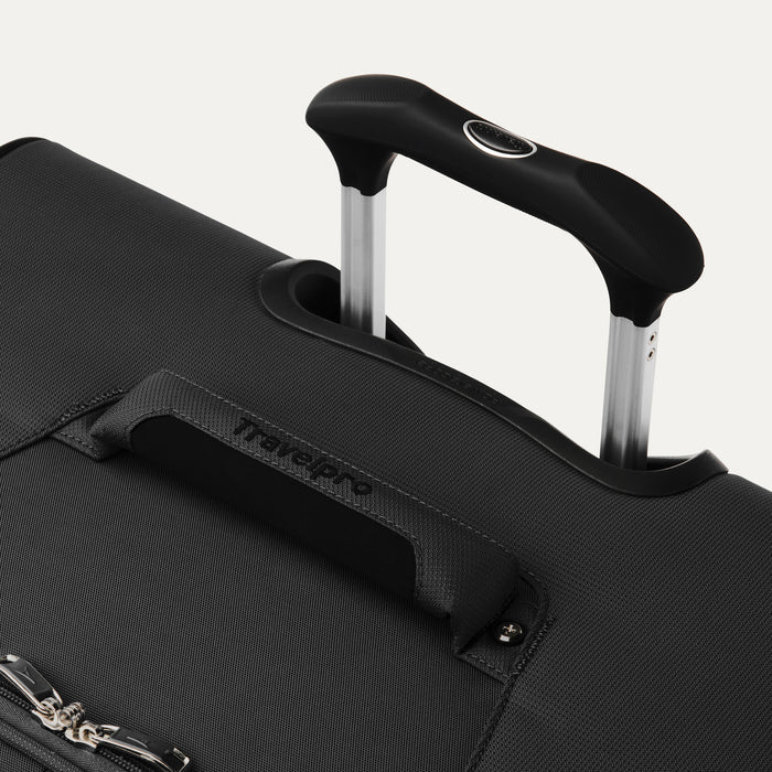 close up of the black travelpro maxlite 5 large check-in spinner showing the ergonomic contour grip on the powerscope lite handle and the cushioned top carry handle.