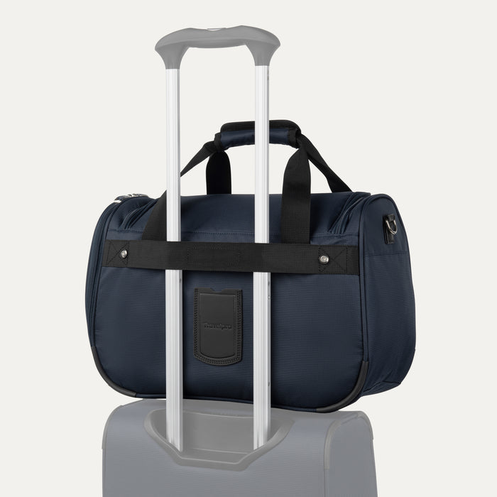 rear view of the midnight blue travelpro maxlite 5 soft tote stacked on a suitcase handle using the integrated rear attachment strap for hands-free mobility.