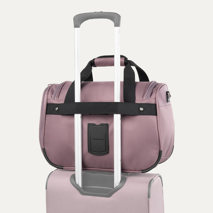 rear view of the dusty rose pink travelpro maxlite 5 soft tote stacked on a suitcase handle using the integrated rear attachment strap for hands-free mobility.