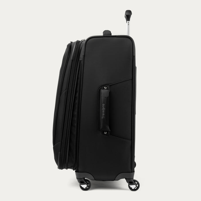 side view of the black travelpro maxlite 5 spinner showing the expanded compartment, side carry handle, and wheels.