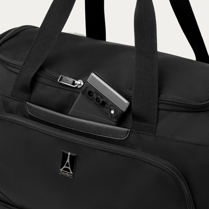 close up of a phone in the front quickslip pocket of the black travelpro maxlite 5 weekender bag.