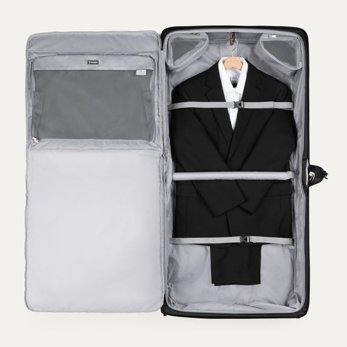 interior view of open black travelpro maxlite checked rolling garment bag showing a suit secured by adjustable hold down straps and foam padded roll bar.