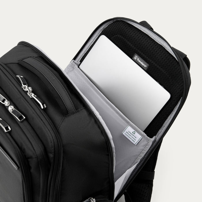 close up of black travelpro maxlite laptop backpack showing a silver laptop inside the padded laptop sleeve with interior sustainability label.