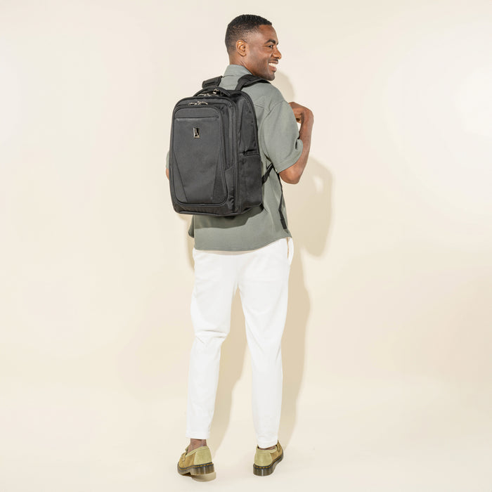 lifestyle view of a man wearing the black travelpro maxlite laptop backpack showing the padded shoulder straps and comfortable fit.
