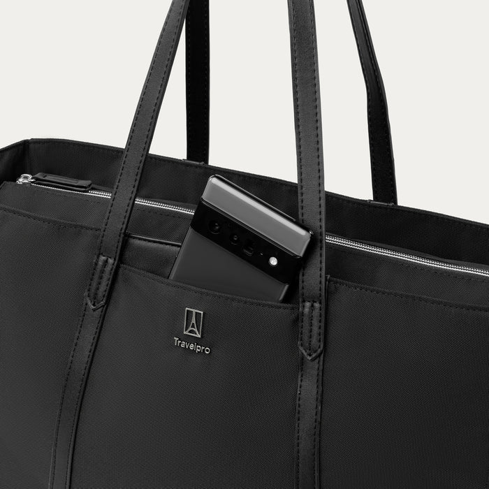 close up of the travelpro quickslip front pocket on the black maxlite women's tote with a cell phone tucked inside showing the magnetic closure.