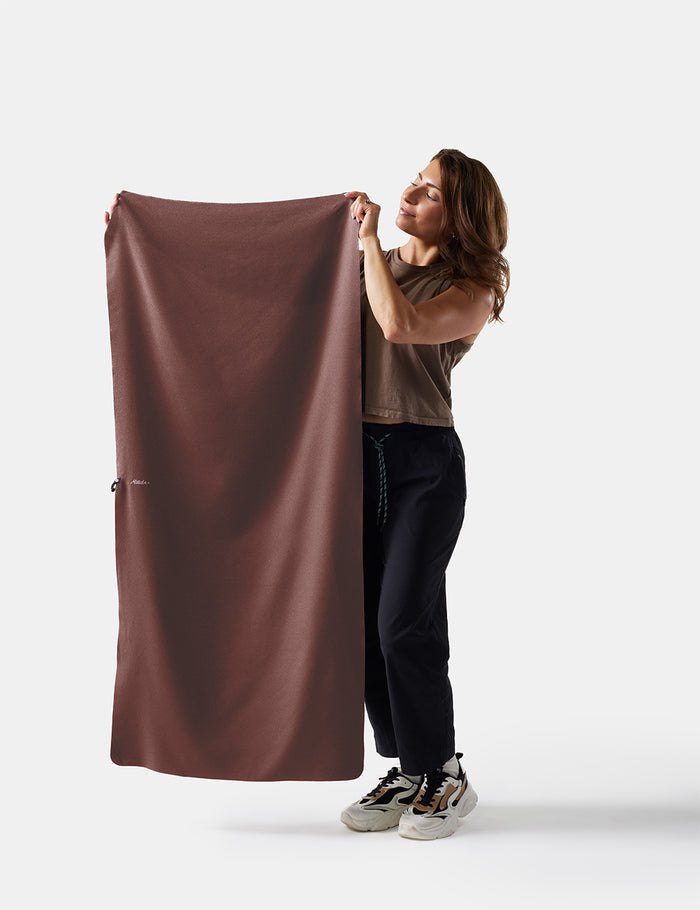 person holding garnet towel on white background
