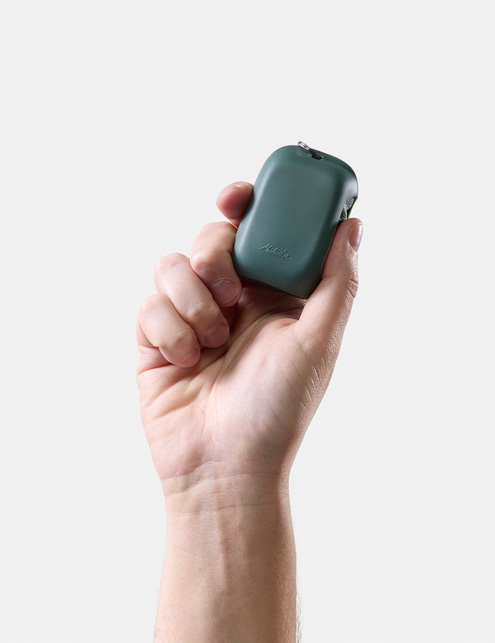 hand holding green silicone case on white background